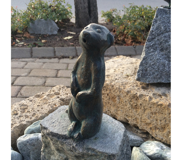 Rottenecker Bronze-Erdmännchen groß auf Granit, wasserspeiend